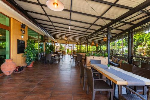 a restaurant with tables and chairs and plants at Hotel Julia in Sveti Vlas