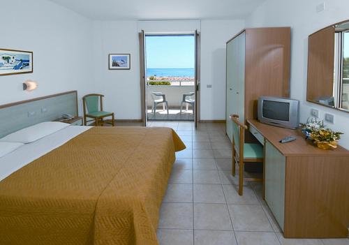 Pokój hotelowy z łóżkiem, biurkiem i telewizorem w obiekcie Hotel Miramare w mieście Giulianova