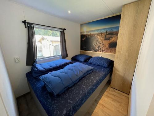 a small bedroom with a bed and a window at Vakantiepark Klein Vink - A10 in Arcen