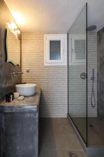 a bathroom with a sink and a glass shower at Live & Dream in Vrisi/ Mykonos