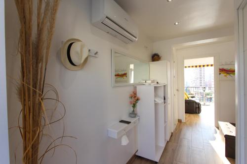 een kamer met een witte muur en een spiegel bij Lantana Suite-Turis Benidorm in Benidorm