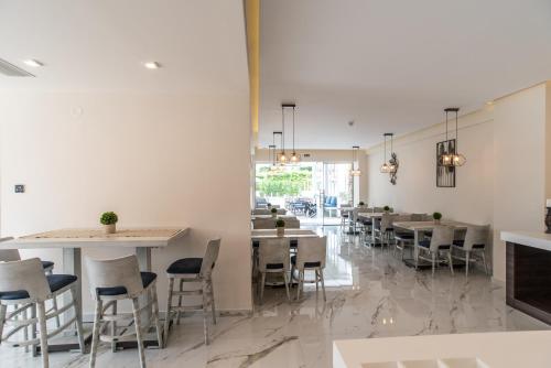a restaurant with tables and chairs in a room at Lagaria Hotel II in Asprovalta