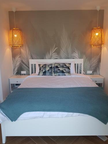 sypialnia z białym łóżkiem z dwoma światłami w obiekcie Hampton House w Rowach