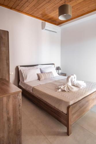 a bedroom with a large bed with a wooden ceiling at Fotini Apartments in Preveza