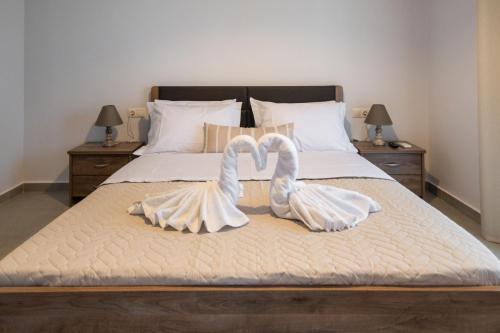 dos cisnes blancos están sentados en una cama en Fotini Apartments, en Preveza
