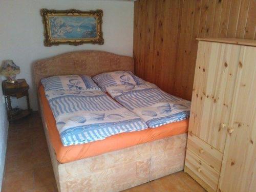 a small bed in a room with a wooden wall at kleines-Ferienhaus-nur-5-Auto-min-von-Binz in Lubkow