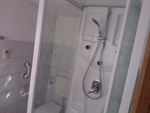uma casa de banho com um chuveiro e um WC. em kleines-Ferienhaus-nur-5-Auto-min-von-Binz em Lubkow