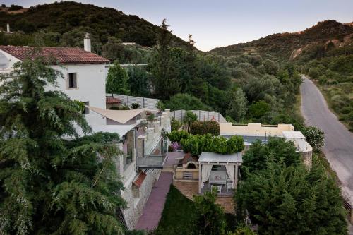 a house on the side of a hill with a road at Verekinthos Villas - Pool, Hot Tub, BBQ, Kids Playground, Stunning Mountain Views in Gerolakkos