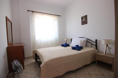 a bedroom with a bed with blue pillows on it at Grammeno Seaside Studios in Palaiochóra