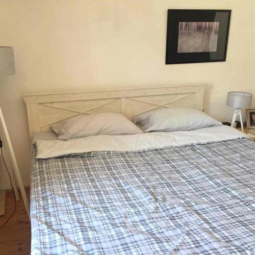 a bed with a wooden headboard in a bedroom at HOSTEL EMI in Kavadarci