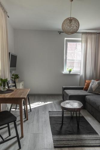 a living room with a couch and a table at W Sercu Mazur in Harsz
