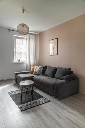 a living room with a gray couch and a table at W Sercu Mazur in Harsz