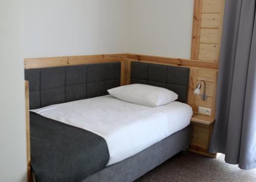 a bedroom with a large bed with a wooden headboard at Zajazd Gołębiowski in Lipsko