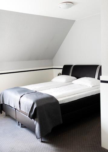 a bedroom with a large bed with white sheets at Zajazd Gołębiowski in Lipsko