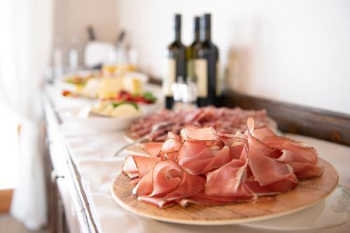 two plates of meat on a counter with bottles of wine at Magari Estates Boutique Hotel in Colognola ai Colli