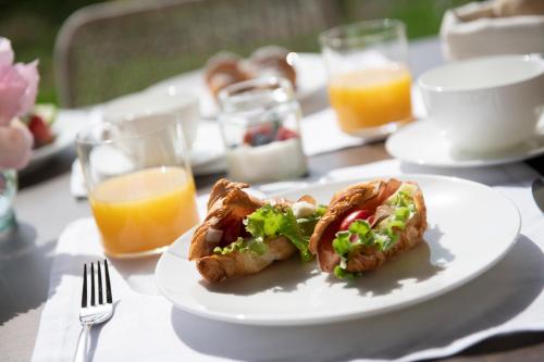 a white plate with a sandwich on a table at Magari Estates Boutique Hotel in Colognola ai Colli
