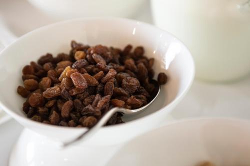 a bowl of raisins on a table with a spoon at Magari Estates Boutique Hotel in Colognola ai Colli