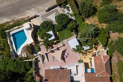 an overhead view of a house with a swimming pool at Verekinthos Villas - Pool, Hot Tub, BBQ, Kids Playground, Stunning Mountain Views in Gerolakkos