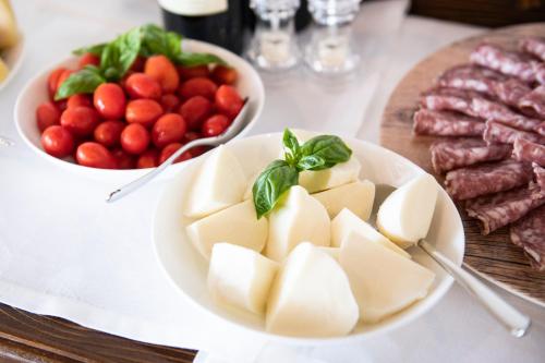 a table with plates of food and a bowl of vegetables at Magari Estates Boutique Hotel in Colognola ai Colli