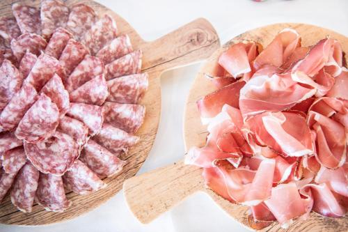 two wooden cutting boards with meat on them at Magari Estates Boutique Hotel in Colognola ai Colli