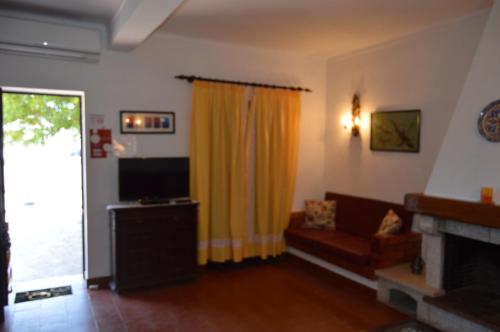 een woonkamer met een bank en een televisie bij CASA DA AVÓ in Vila Nova de Cacela