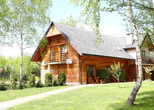 a log cabin with a porch and a window at Zajazd Gołębiowski in Lipsko