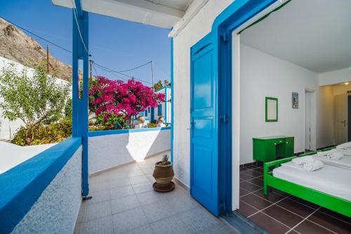 a room with a bed and a balcony with flowers at Ancient Thera Apartments in Kamari