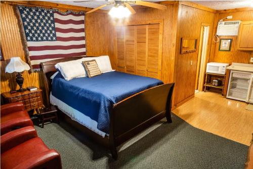 a bedroom with a bed with an american flag on the wall at Mountain Aire Cottages, Inn, & Glamping in Clayton