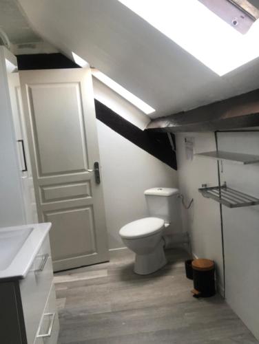 La salle de bains est pourvue de toilettes et d'une porte blanche. dans l'établissement Jolie Appartement 2 chambres a dunkerque, à Saint-Pol-sur-Mer