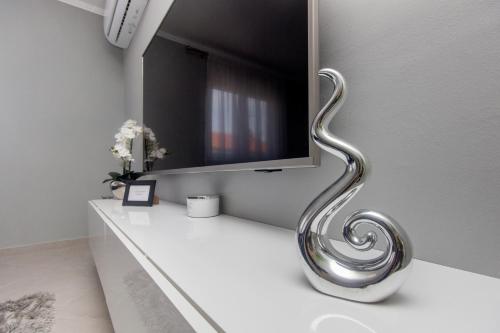 a wall mounted tv with a silver handle on a wall at Silver Lux Suite - NEW in Zaboric