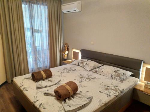 a bedroom with a bed with two pillows on it at Apartment Melody in Burgas City