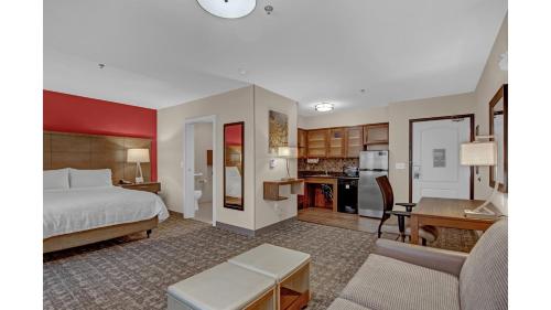 a hotel room with a bed and a kitchen at Staybridge Suites Salt Lake-West Valley City by IHG in West Valley City