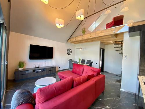 a living room with a red couch and a tv at Apartament LUX Ustroń in Ustroń