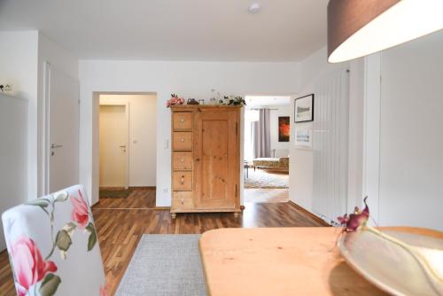 a living room with a table and a wooden dresser at Apartments Zum Ybbsturm in Waidhofen an der Ybbs