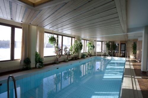a swimming pool in a building with windows at Hotel Ivalo in Ivalo