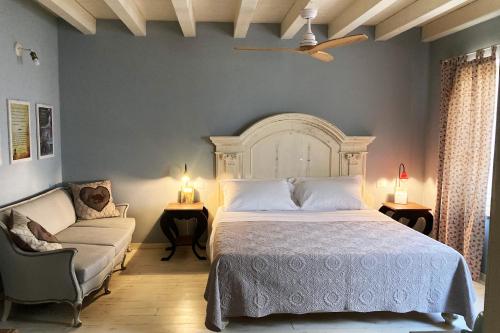 um quarto com uma cama, um sofá e uma cadeira em B&B Antique Maison em Soave