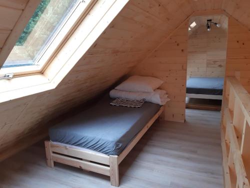 a room with two beds in a wooden cabin with a window at Family Chillout Wisełka in Wisełka
