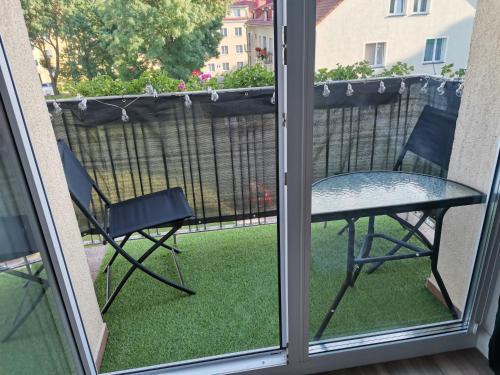 a patio with a table and chairs on a balcony at Apartament z widokiem na Zamek in Malbork