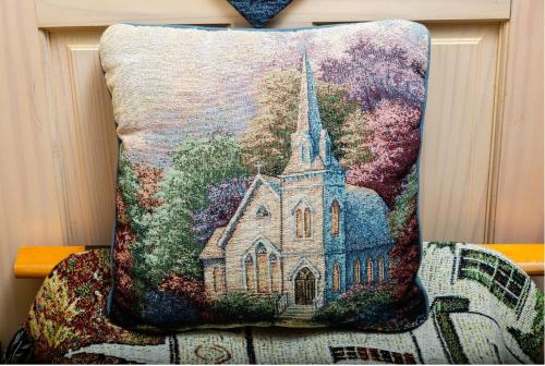 a pillow with a picture of a church at Mountain Aire Cottages, Inn, & Glamping in Clayton