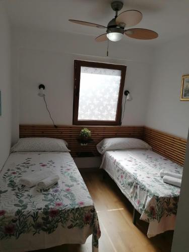 two beds in a room with a window at Malvarrosa apartamentos in Valencia