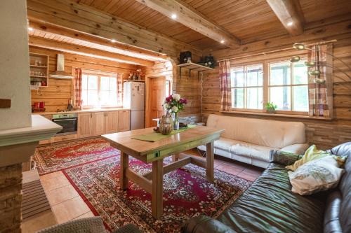 a living room with a couch and a table in a kitchen at Baltās anemones in Jumprava