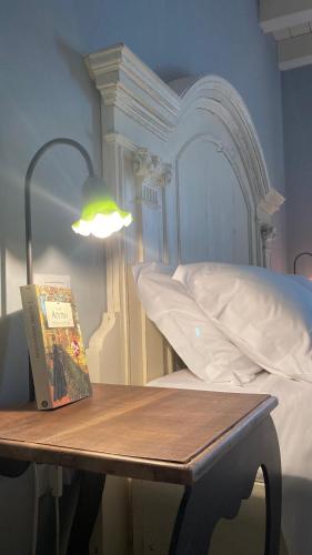 a book sitting on a table next to a bed at B&B Antique Maison in Soave