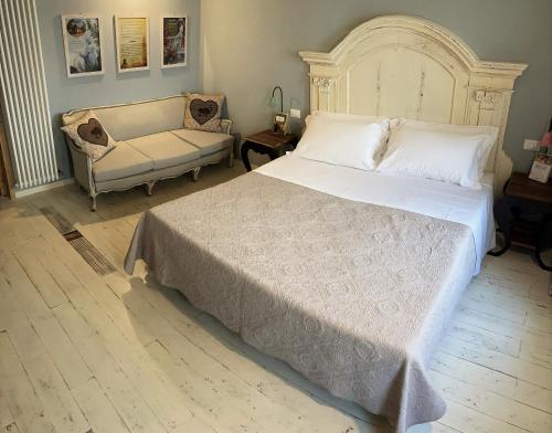 a bedroom with a large white bed and a couch at B&B Antique Maison in Soave