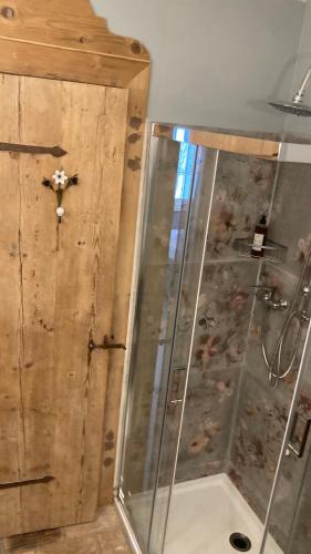 a shower with a glass door in a room at B&B Antique Maison in Soave