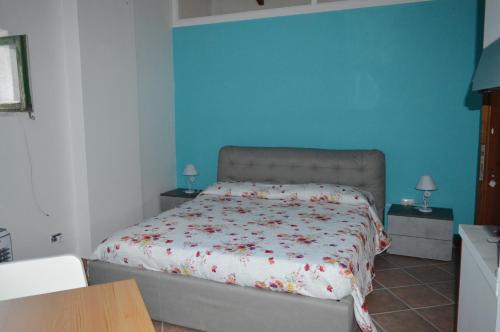 1 dormitorio con cama y pared azul en b&b Don Peppe - Don Ilario, en San Mauro Cilento