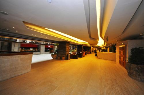 a lobby of a building with wooden floors and lights at The Salisbury - YMCA of Hong Kong in Hong Kong