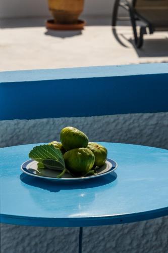 a plate of green fruit on a blue table at Ancient Thera Apartments in Kamari