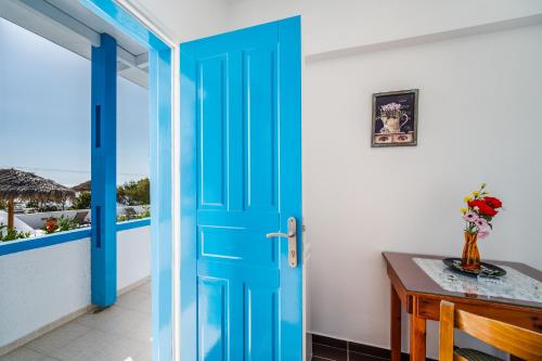 a blue door in a room with a desk and a window at Ancient Thera Apartments in Kamari