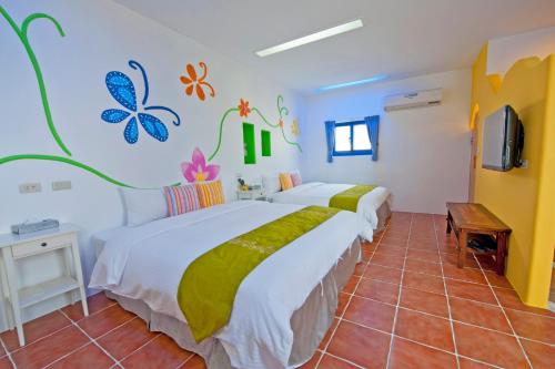 a bedroom with two beds and a tv at Haisu Homestay in Eluan