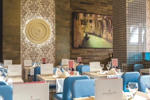 a dining room with tables and chairs and a painting on the wall at Riu Republica - Adults Only - All Inclusive in Punta Cana